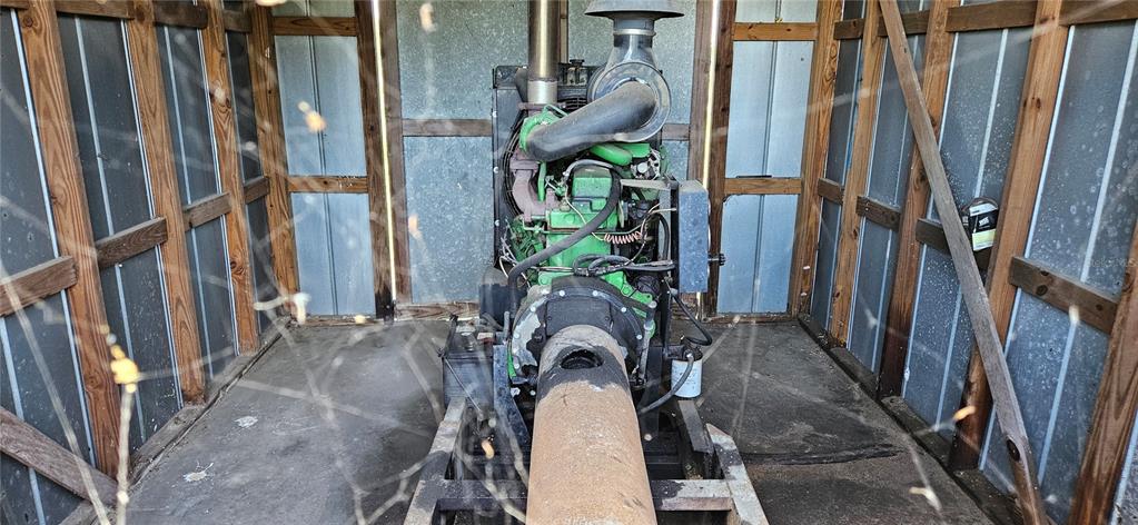 A large industrial engine sits inside a small, metal-sided shed with wooden framing — MT ZION CHURF, FROSTPROOF, FL