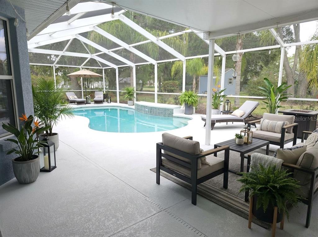 A screened-in patio features a swimming pool, lounge chairs, and outdoor seating furniture — 11179 SW 61ST CIRCLE, OCALA, FL
