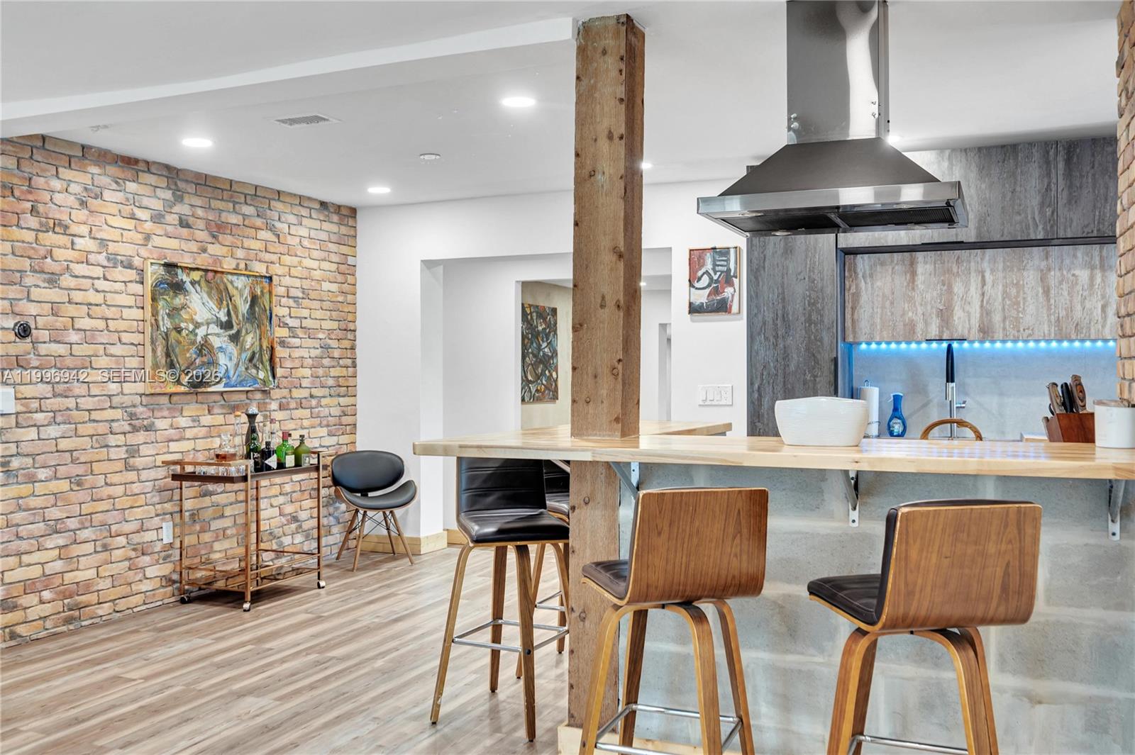A kitchen with a brick wall, wooden support post, and breakfast bar with stools — 9000 NW 12th Ave, Miami FL 33150, MIAMI, FL