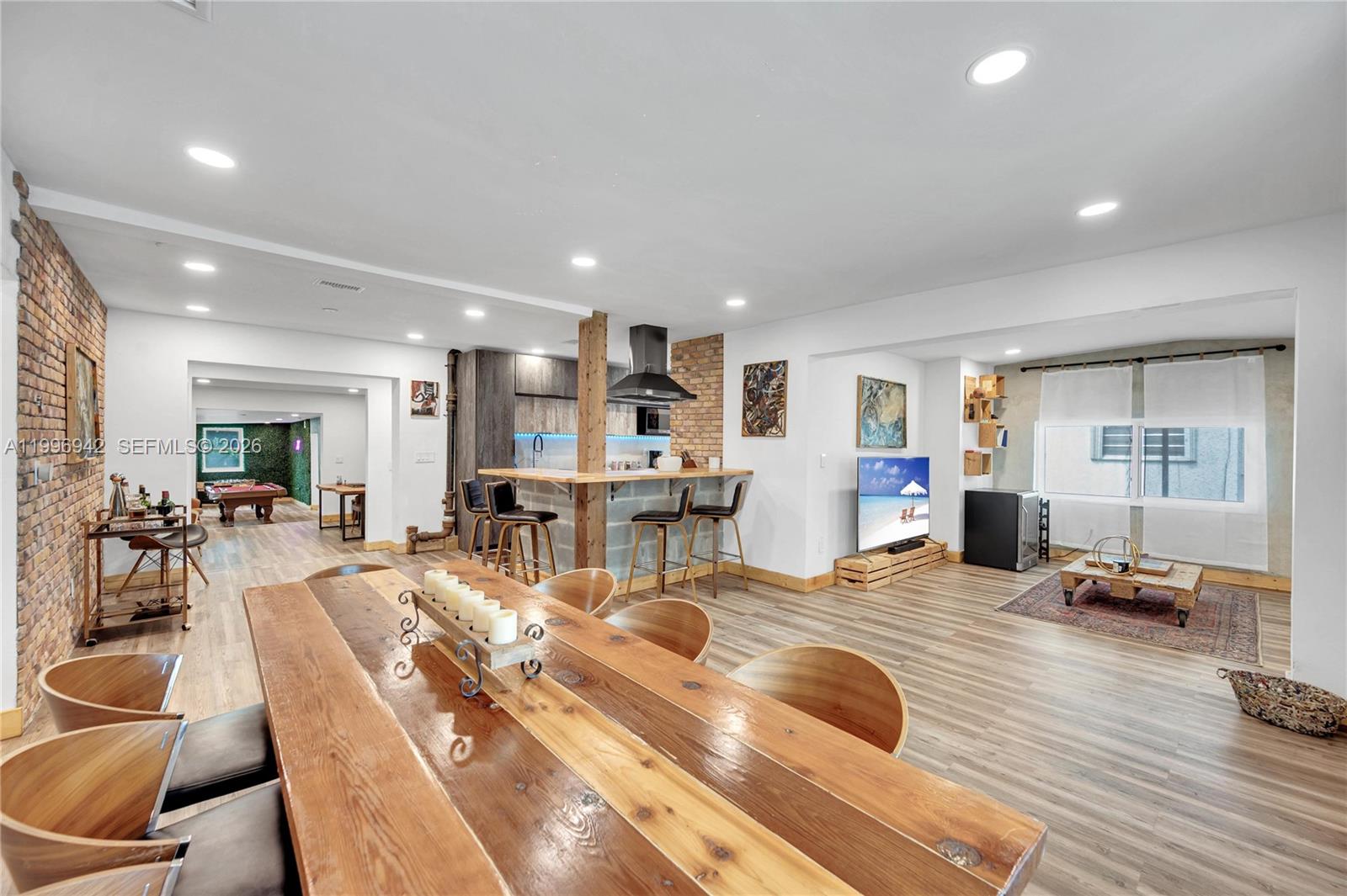 An open-concept living area features a dining table, kitchen island, and a lounge space — 9000 NW 12th Ave, Miami FL 33150, MIAMI, FL