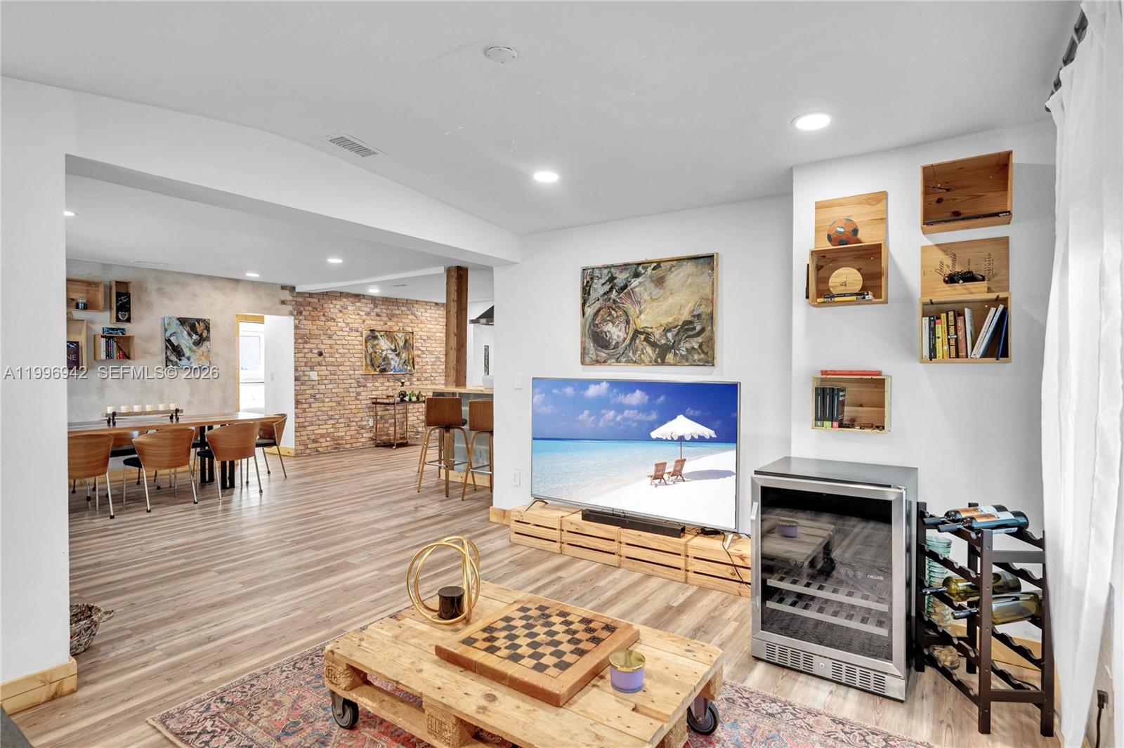 A living room features a television on a pallet stand, a wooden coffee table, and a wine cooler — 9000 NW 12th Ave, Miami FL 33150, MIAMI, FL