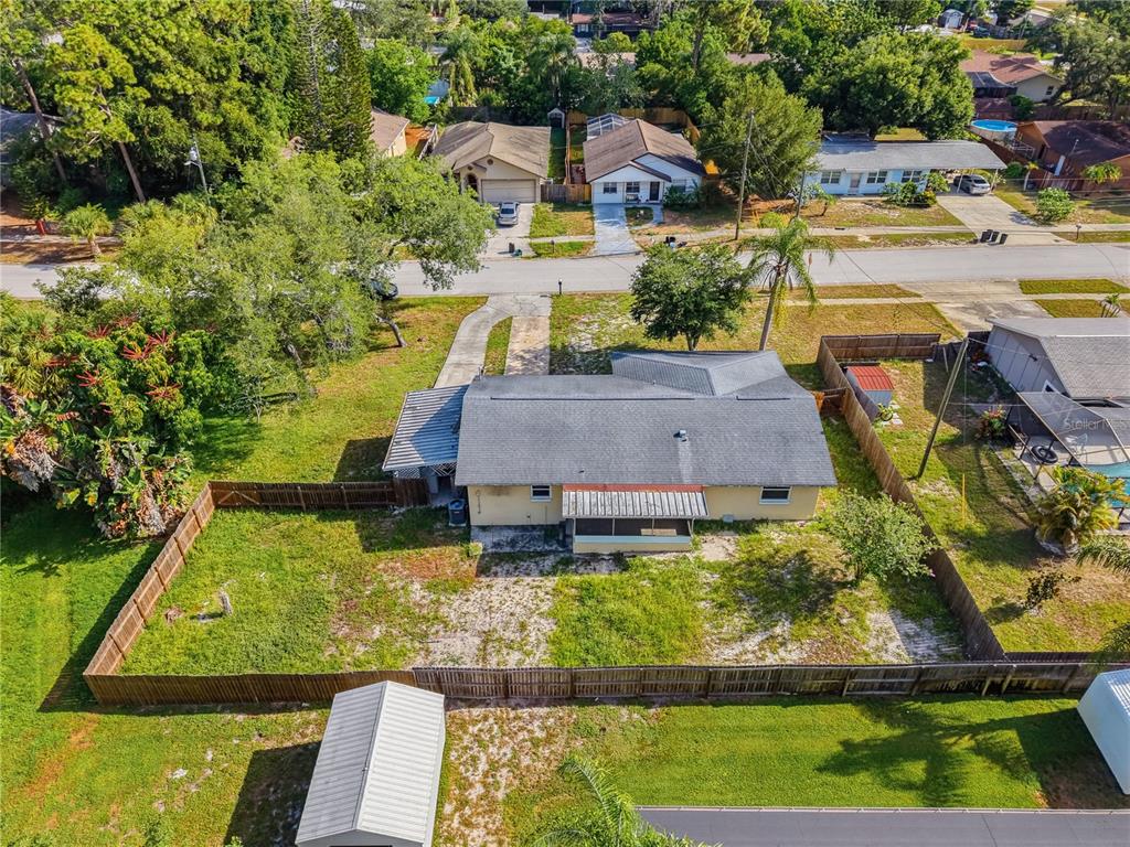 An aerial view shows a single-story house with a fenced backyard and a detached shed — 1116 E OAKWOOD STREET, TARPON SPRINGS, FL