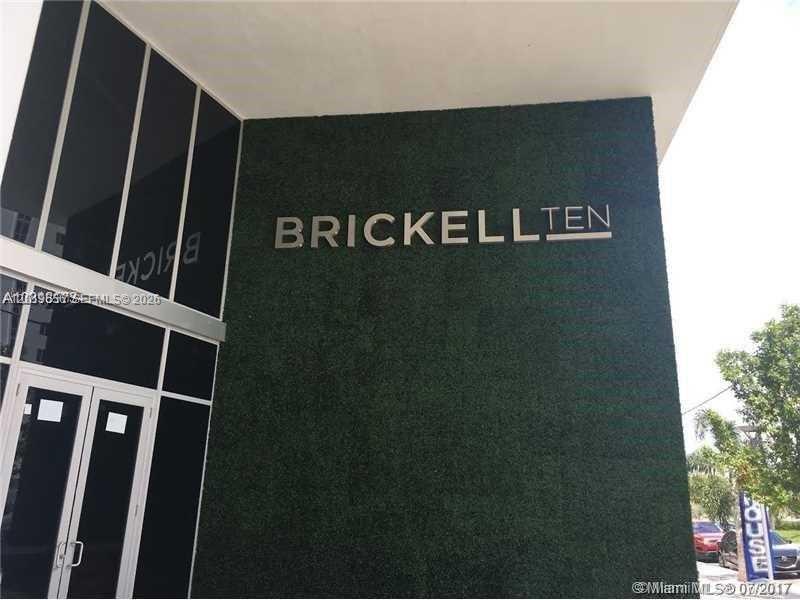 The exterior entrance of a building features a green wall with the sign Brickell Ten — 1010 SW 2nd Ave # 1105, Miami FL 33130, MIAMI, FL
