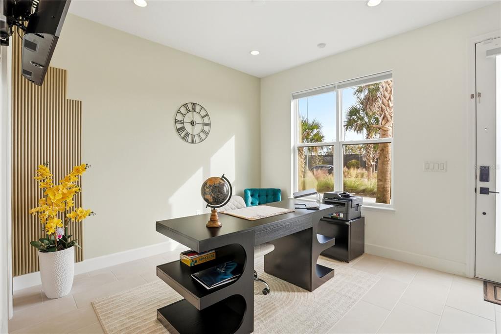 A home office features a modern black desk, a globe, a wall clock, and a window — 2038 PACKING DISTRICT WAY, ORLANDO, FL