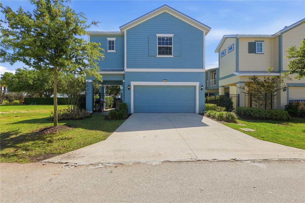 A two-story blue house features a two-car garage and a concrete driveway — 1428 REUNION BOULEVARD, REUNION, FL