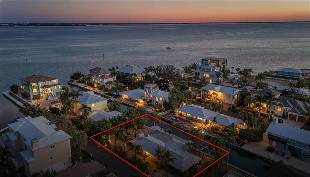 An aerial view shows a waterfront house with a red outline on its property lot — 834 JUNGLE QUEEN WAY, LONGBOAT KEY, FL