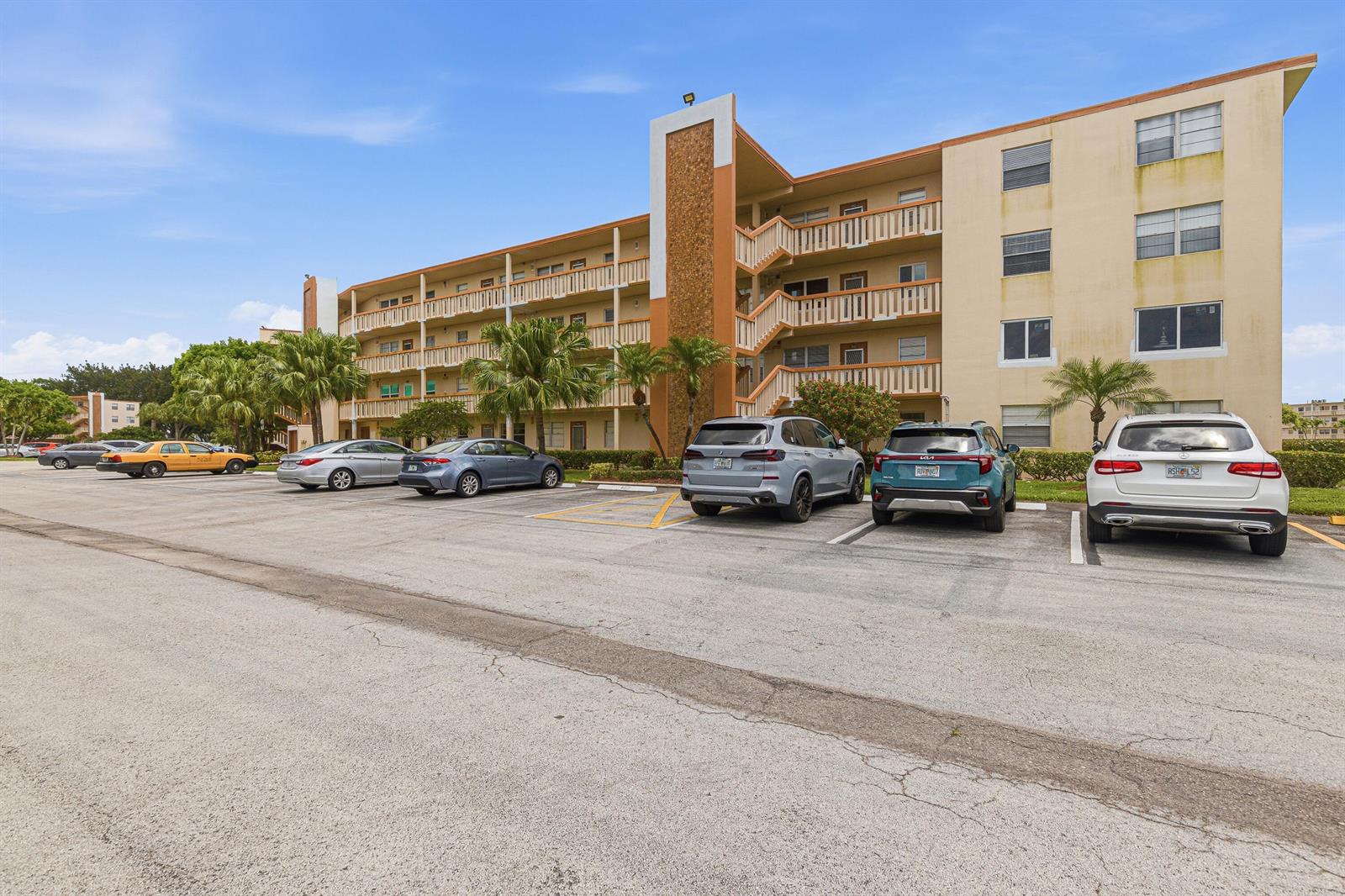A multi-story apartment building with exterior walkways and a parking lot in the foreground — 1025 Newcastle B # 1025, Boca Raton FL 33434, BOCA RATON, FL