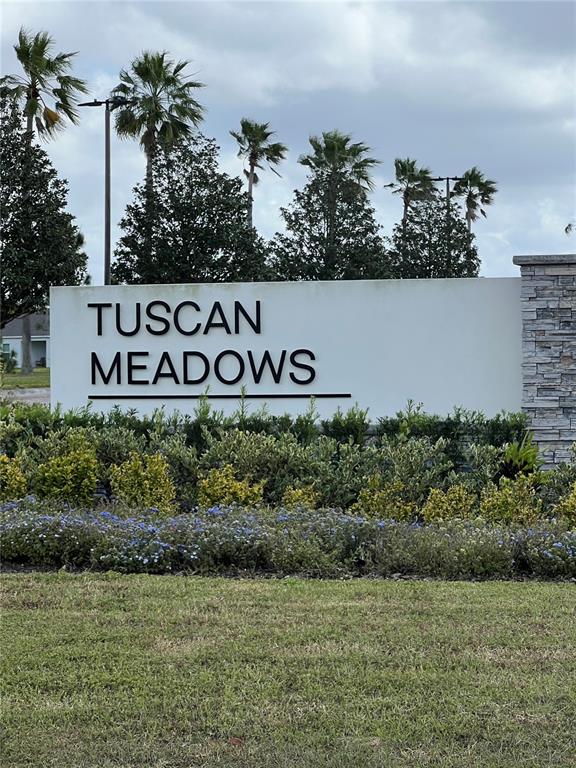 A white monument sign with black lettering reads Tuscan Meadows in front of palm trees — 3085 BELLA VISTA DRIVE, DAVENPORT, FL