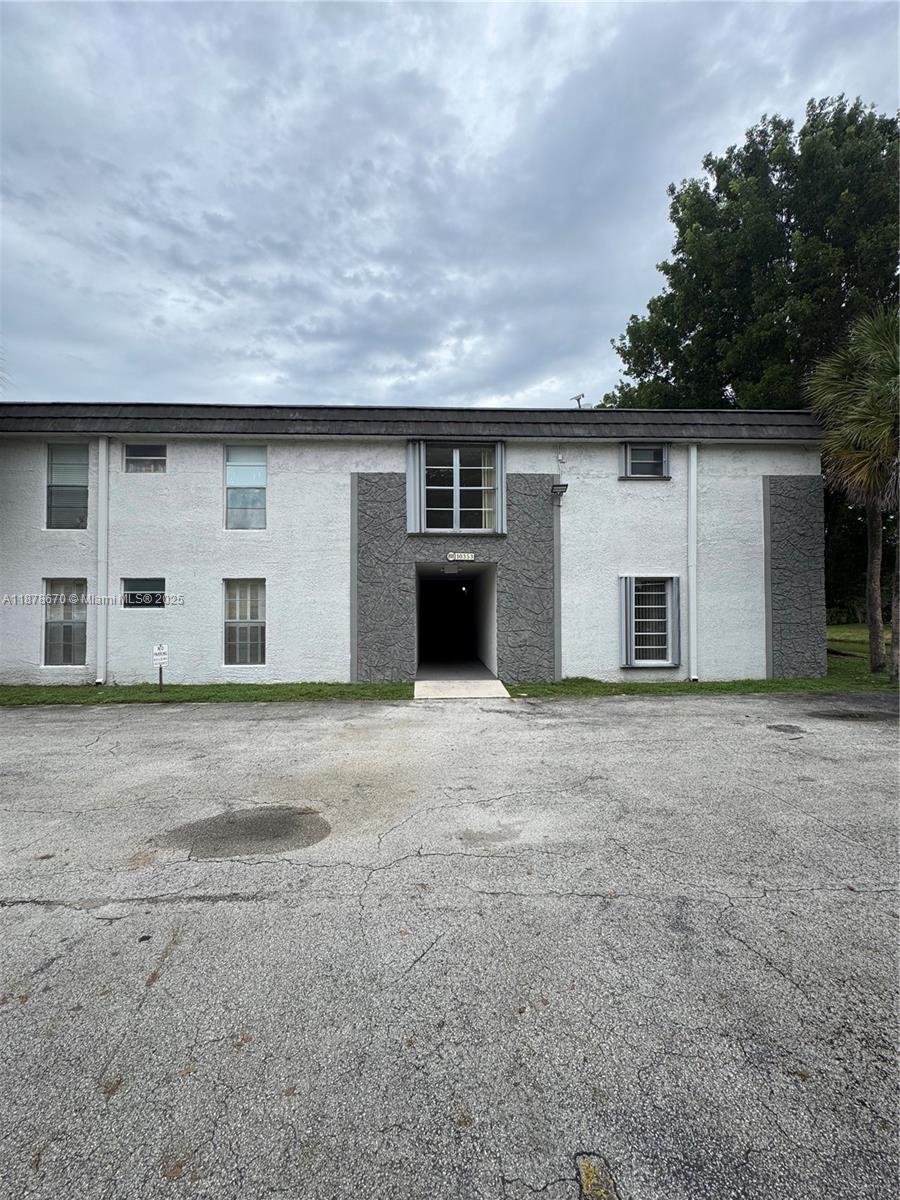 A two-story apartment building exterior features white stucco walls with gray textured accents — 10353 N Kendall Dr, Miami FL 33176, MIAMI, FL