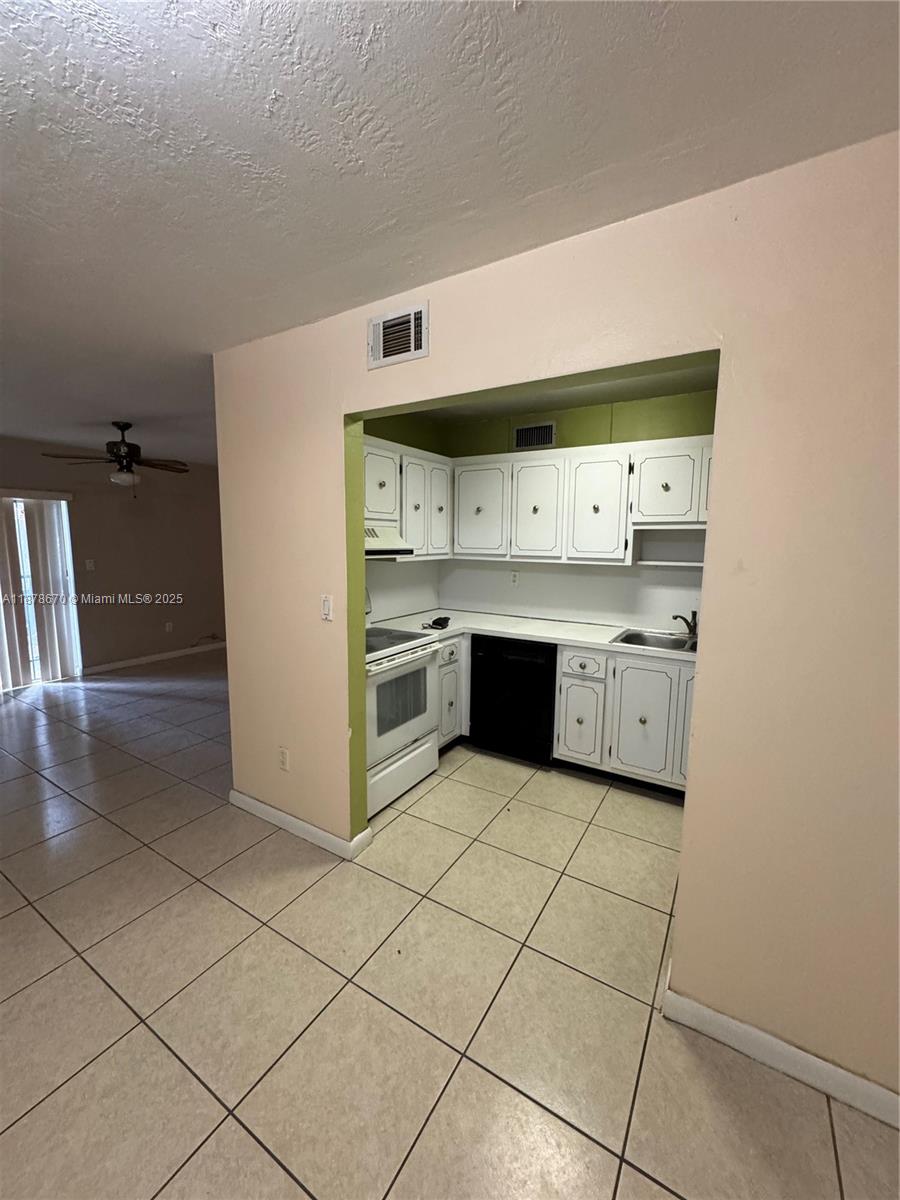 A kitchen with white cabinets, white appliances, and light-colored tile flooring — 10353 N Kendall Dr, Miami FL 33176, MIAMI, FL