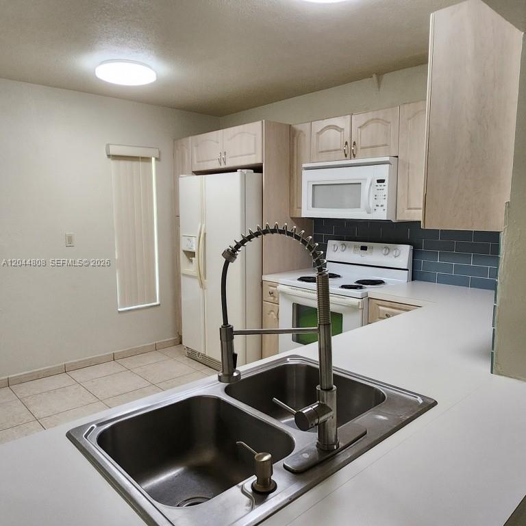 A kitchen features white cabinets, stainless steel appliances, and a gray subway tile backsplash — 11249 SW 169th St # V4831, Miami FL 33157, MIAMI, FL