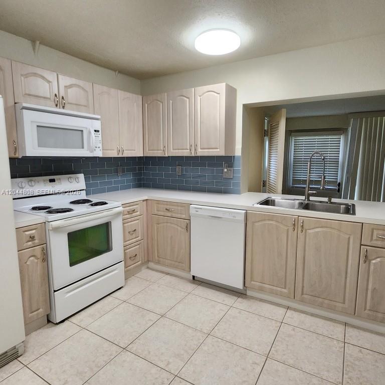 A kitchen features white cabinets, stainless steel appliances, a blue subway tile backsplash, and countertops — 11249 SW 169th St # V4831, Miami FL 33157, MIAMI, FL