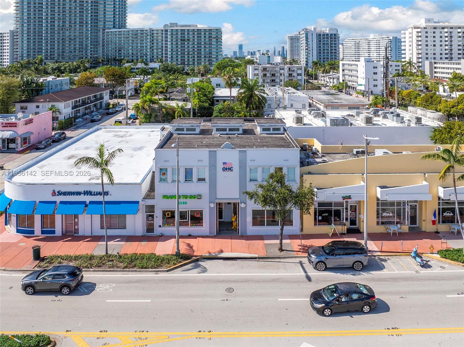 An aerial view shows a two-story commercial building flanked by retail shops along a street — 1558 Alton Rd, Miami Beach FL 33139, MIAMI BEACH, FL