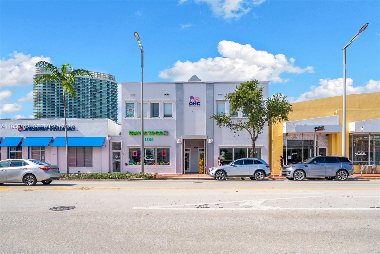 A two-story commercial building with a central entrance is flanked by single-story storefronts on a street — 1558 Alton Rd, Miami Beach FL 33139, MIAMI BEACH, FL