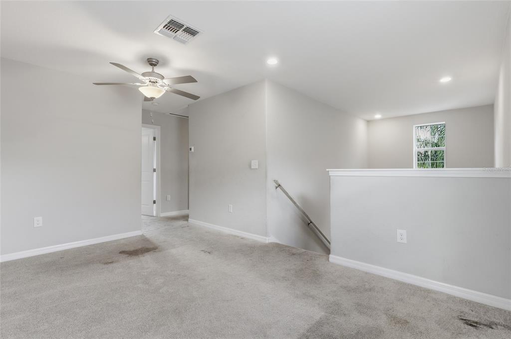 A carpeted loft area features a ceiling fan, recessed lighting, and a staircase with railing — 17237 WHITE MANGROVE DRIVE, WIMAUMA, FL