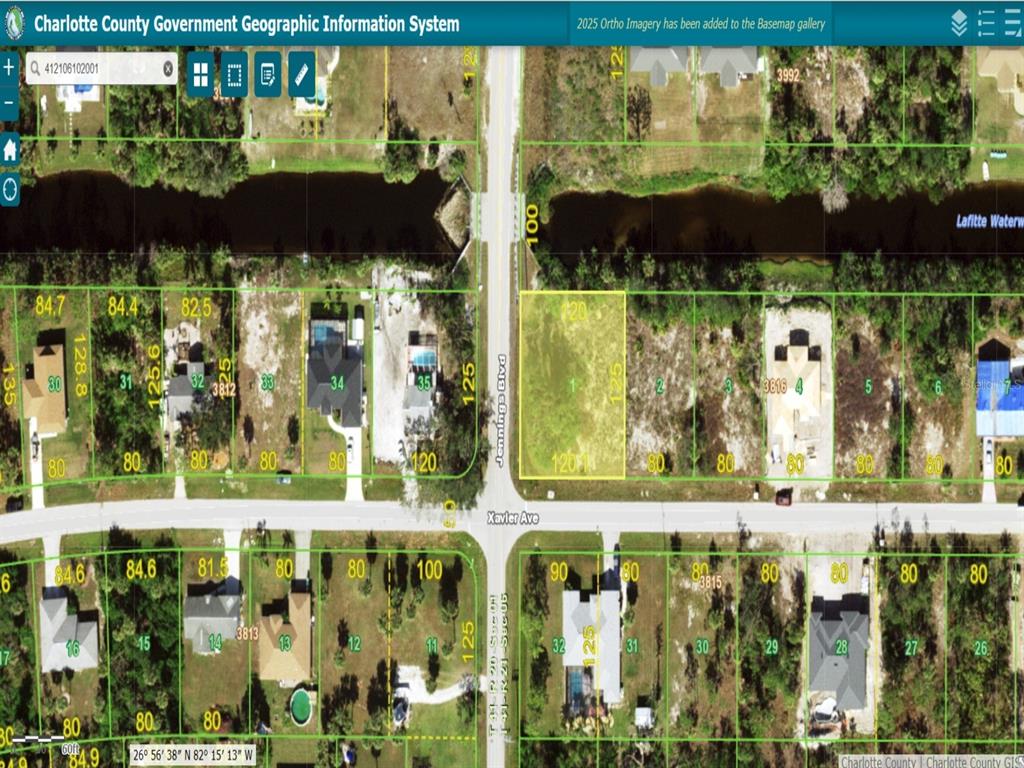 This is a satellite map showing a vacant residential lot highlighted in yellow near a canal — 12010 XAVIER AVENUE, PORT CHARLOTTE, FL