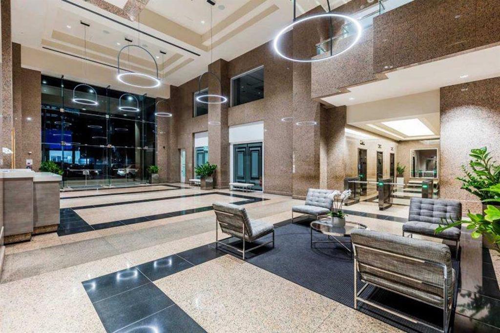 A modern lobby features granite floors, high ceilings, circular pendant lights, and a seating area — 270 MUÑOZ RIVERA, SAN JUAN, PR