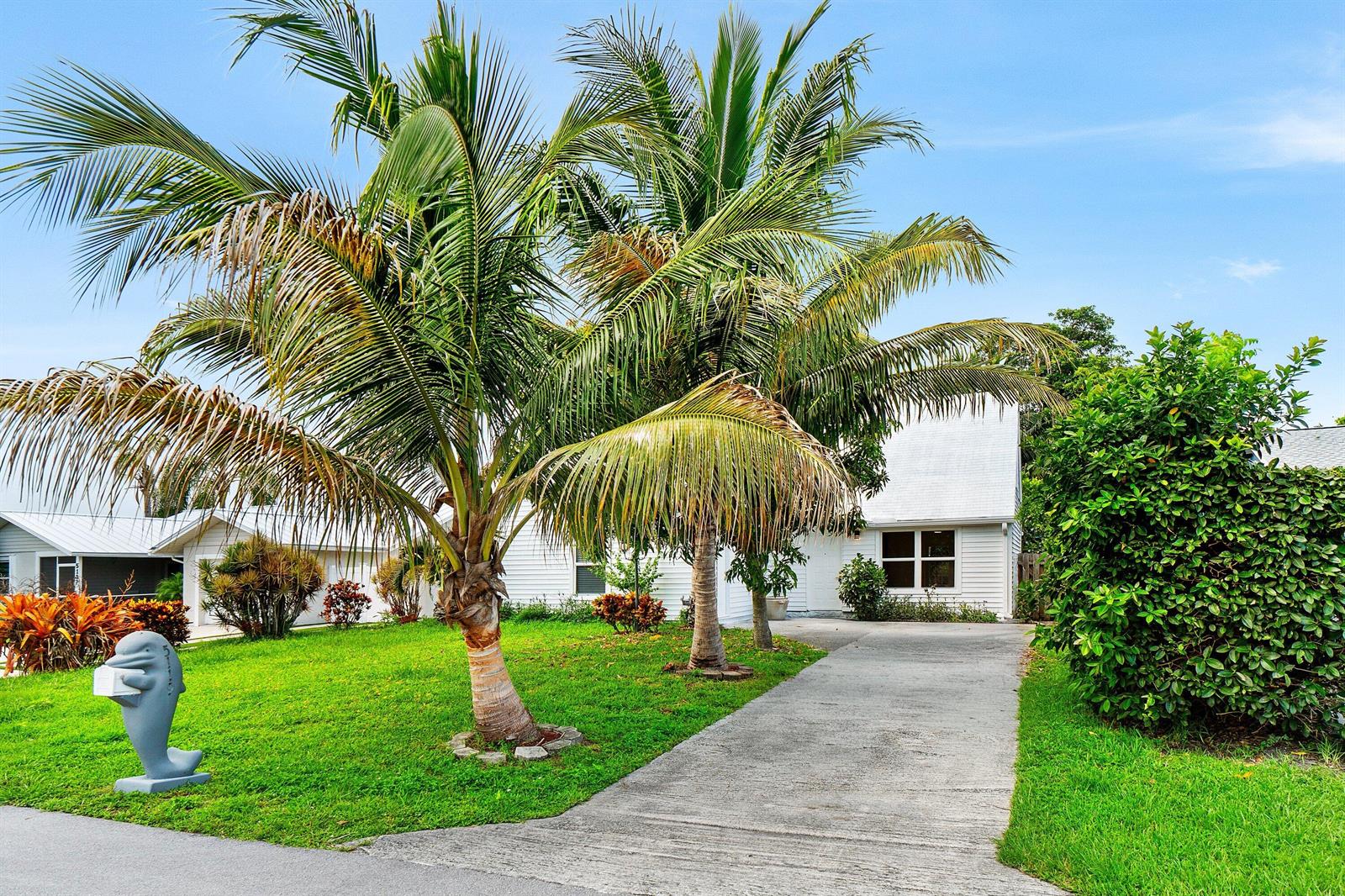 A white house with a concrete driveway and palm trees in the front yard — 5119 Oak Hill Road, Delray Beach FL 33484, DELRAY BEACH, FL