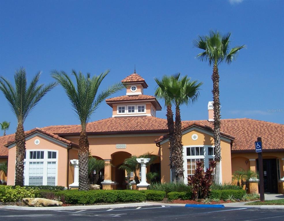 A single-story building with a tiled roof, central cupola, and palm trees in the foreground — 5479 VINELAND ROAD UNIT 9213, ORLANDO, FL