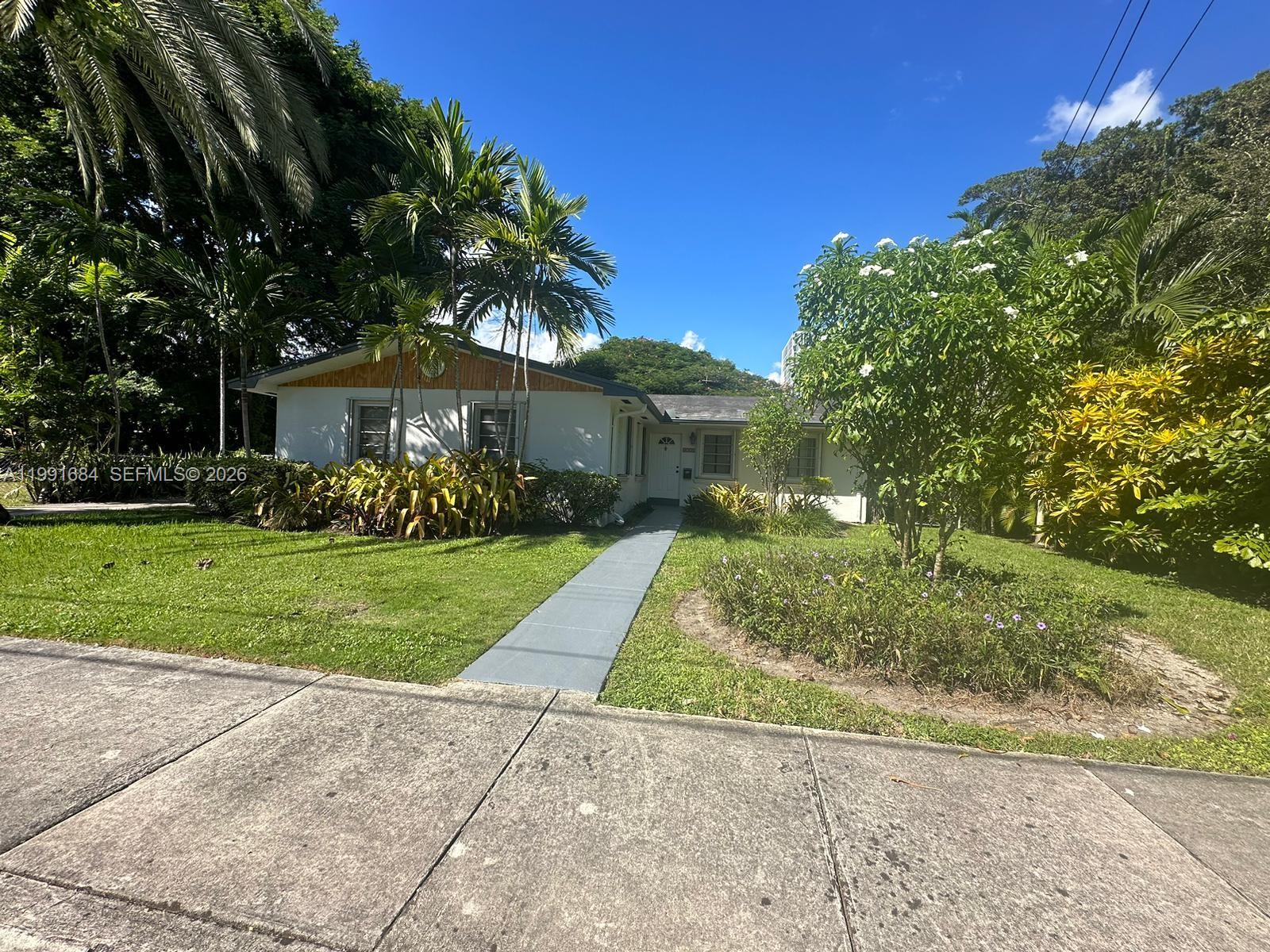 A single-story white house with a gray walkway sits behind a lawn and palm trees — 3755 Oak Ave, Miami FL 33133, MIAMI, FL