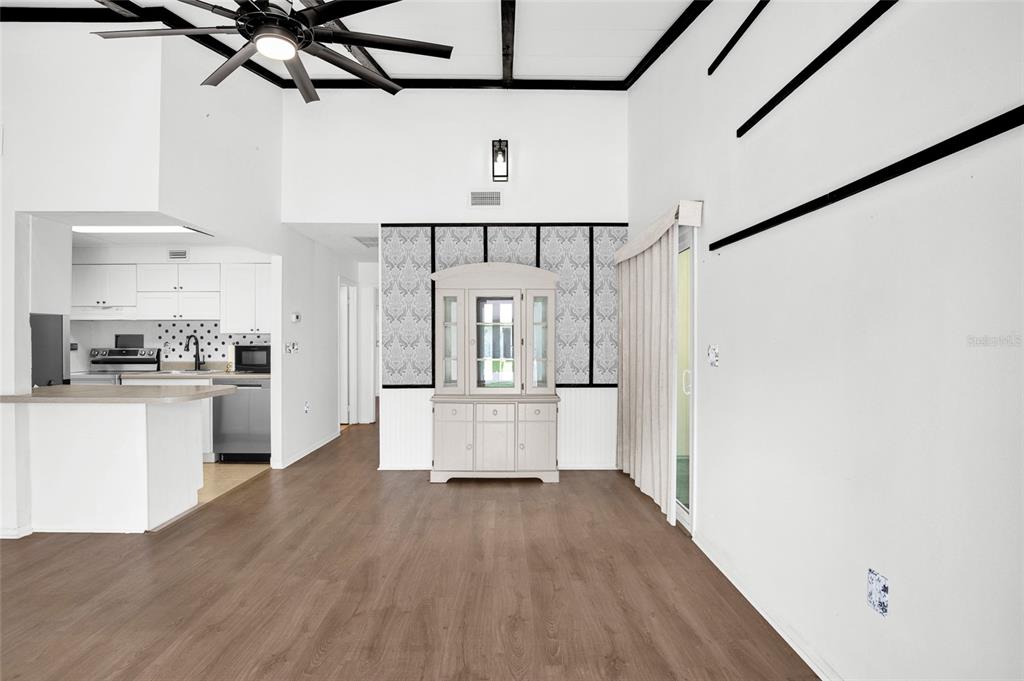 A dining area with wood-look flooring, a hutch, and an adjacent kitchen with white cabinets — 6 COUNTRY CLUB DRIVE UNIT 6A, NEW SMYRNA BEACH, FL