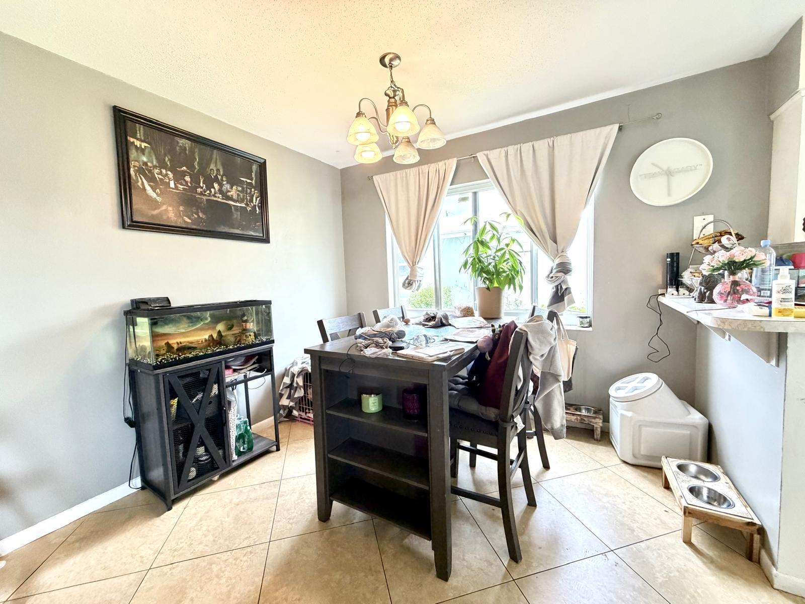 A dining room features a dark wood table, a fish tank, and tile flooring — 4731 NE 21st Terrace # 2, Lighthouse Point FL 33064, LIGHTHOUSE POINT, FL