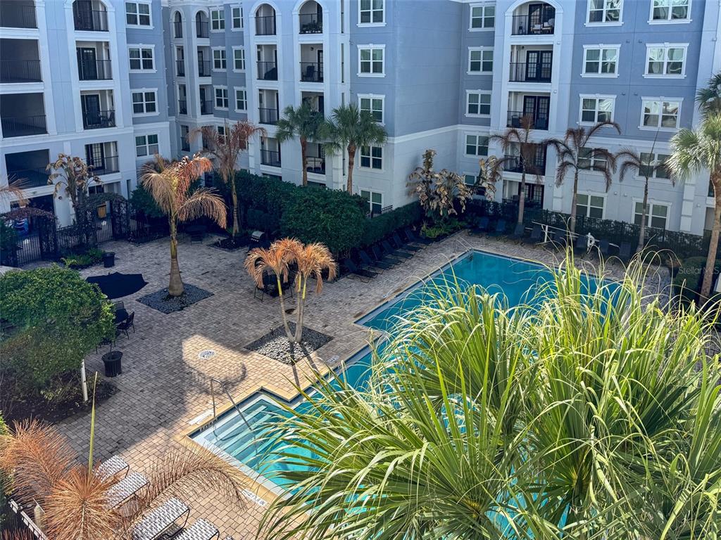 An elevated view of a swimming pool and hot tub surrounded by a paved patio — 202 E SOUTH STREET UNIT 4039, ORLANDO, FL
