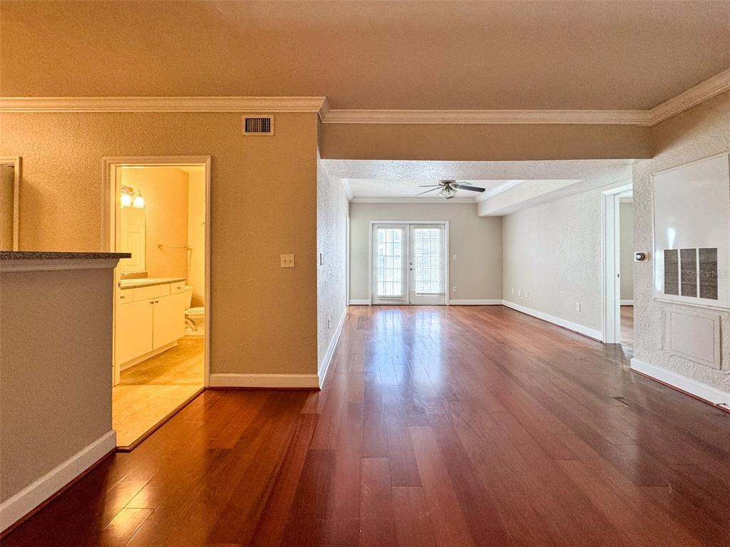 An interior view shows a living area with hardwood floors, a ceiling fan, and French doors — 202 E SOUTH STREET UNIT 4039, ORLANDO, FL