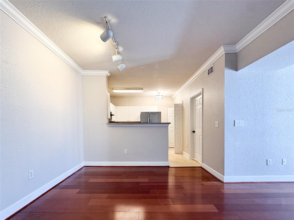 A room with hardwood floors, crown molding, and a pass-through opening to the kitchen — 202 E SOUTH STREET UNIT 4039, ORLANDO, FL