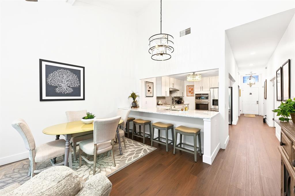 A dining area and kitchen breakfast bar feature white cabinetry, wood floors, and high ceilings — 314 SAND TRAP COVE, LONGWOOD, FL