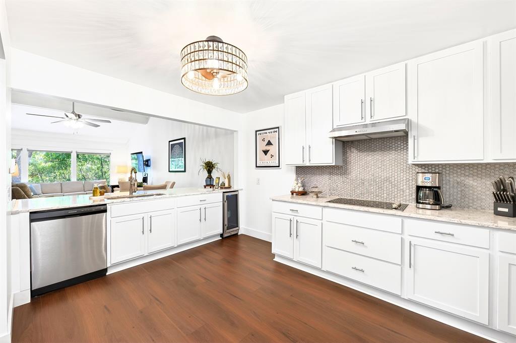 A kitchen with white cabinets, stainless steel appliances, and a hexagonal tile backsplash — 314 SAND TRAP COVE, LONGWOOD, FL