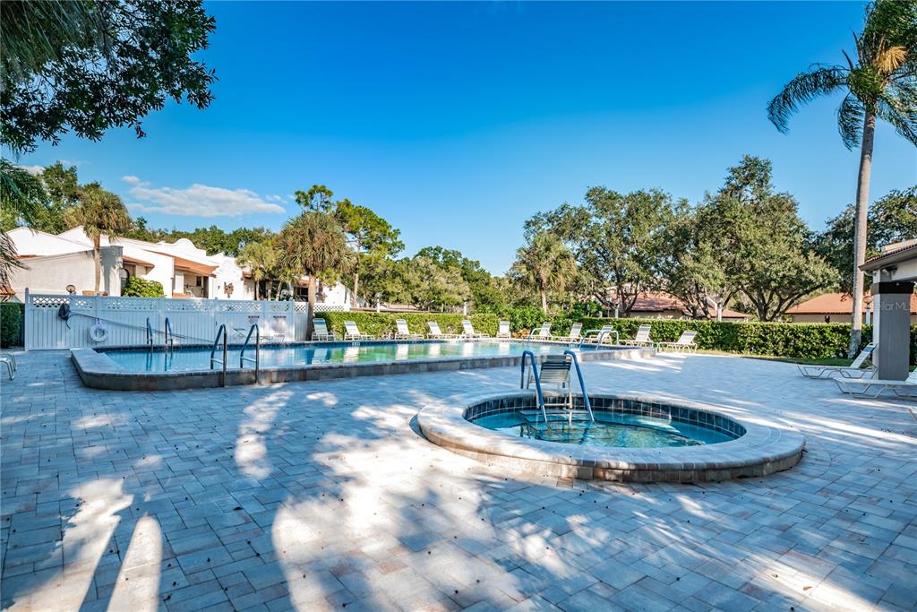 A dining area with a wooden table and chairs sits adjacent to a living room — 3505 TARPON WOODS BOULEVARD UNIT O-403, PALM HARBOR, FL