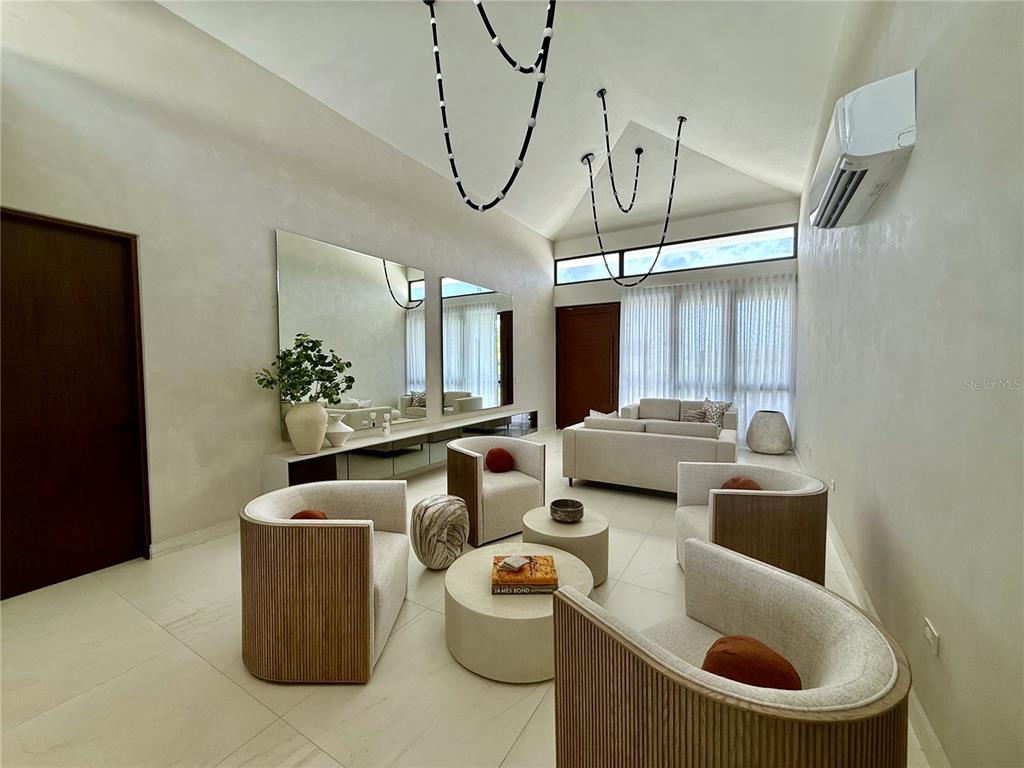 A modern living room features high vaulted ceilings, neutral furniture, and large wall mirrors — 9 LOS LAGOS, HUMACAO, PR