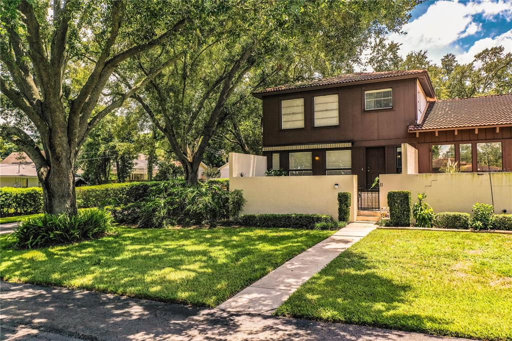 A two-story brown house with a white privacy wall and a concrete walkway — 11 LOMA VERDE UNIT 11, LAKELAND, FL
