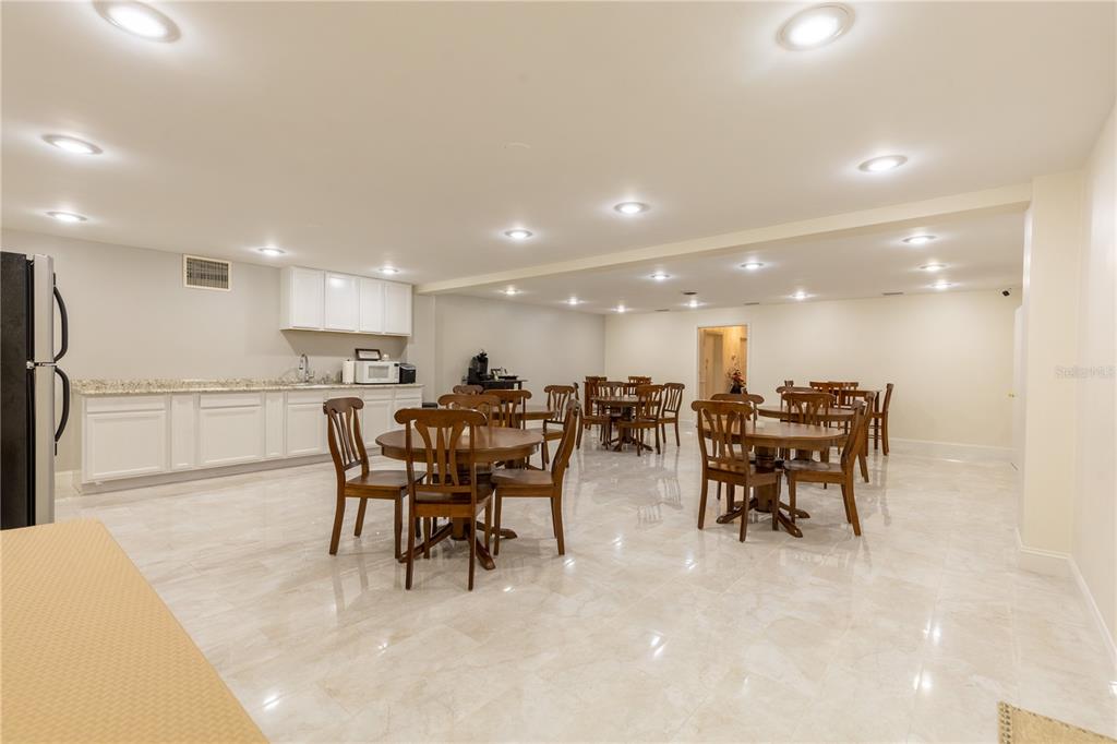 A large, open-concept room features white cabinetry, multiple dining tables, and polished tile flooring — 3530 49TH STREET N, ST PETERSBURG, FL