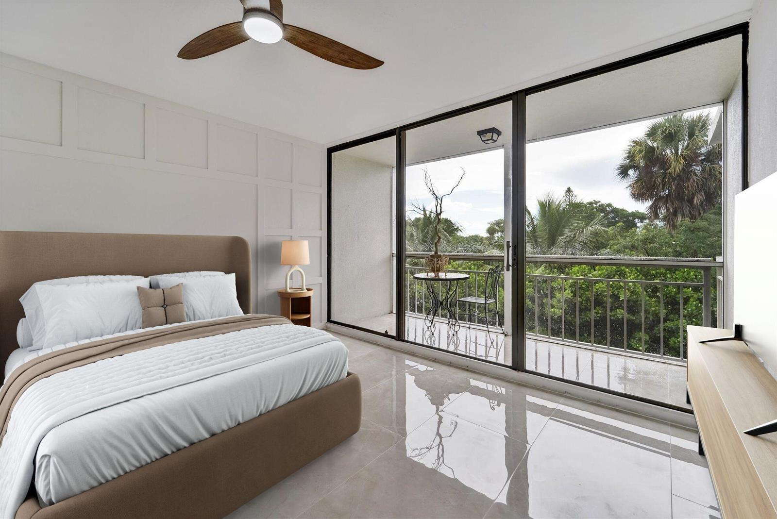 A bedroom with a platform bed, tiled floors, and a balcony overlooking lush green trees — 6181 Balboa Circle # 303, Boca Raton FL 33433, BOCA RATON, FL