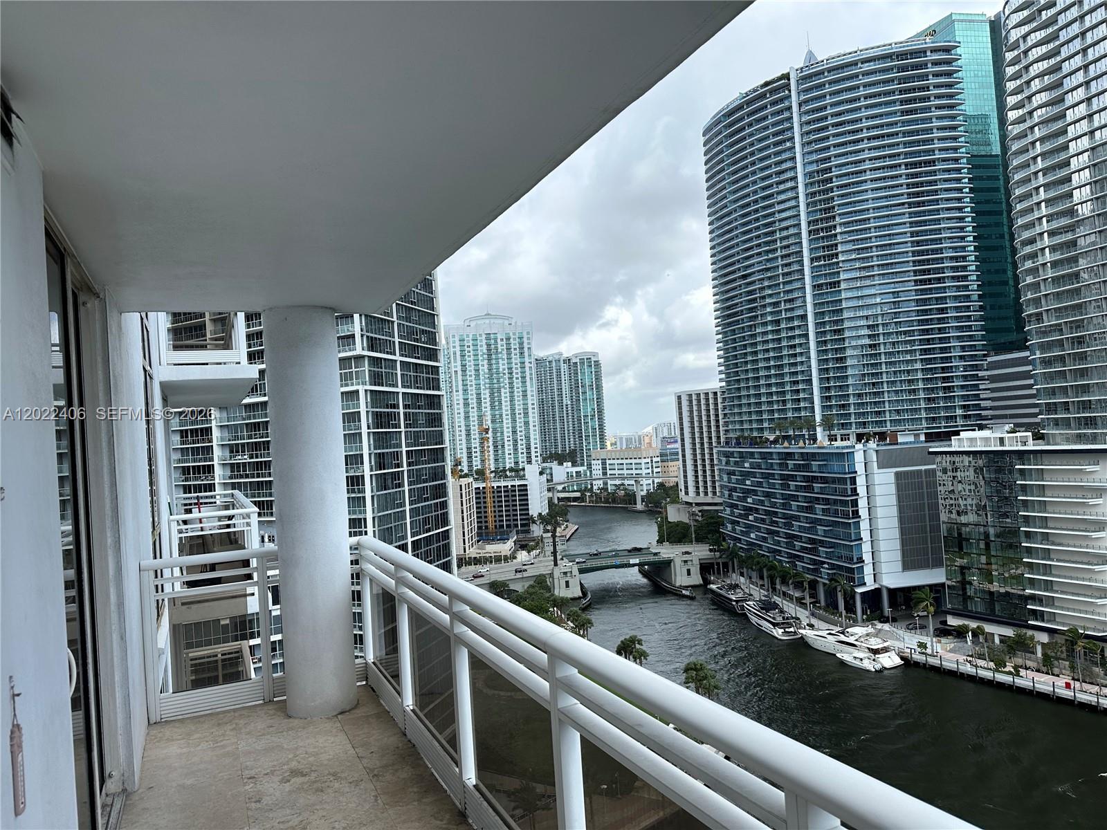A balcony with a white railing overlooks a river surrounded by tall city skyscrapers — 901 Brickell Key Blvd # 2005, Miami FL 33131, MIAMI, FL