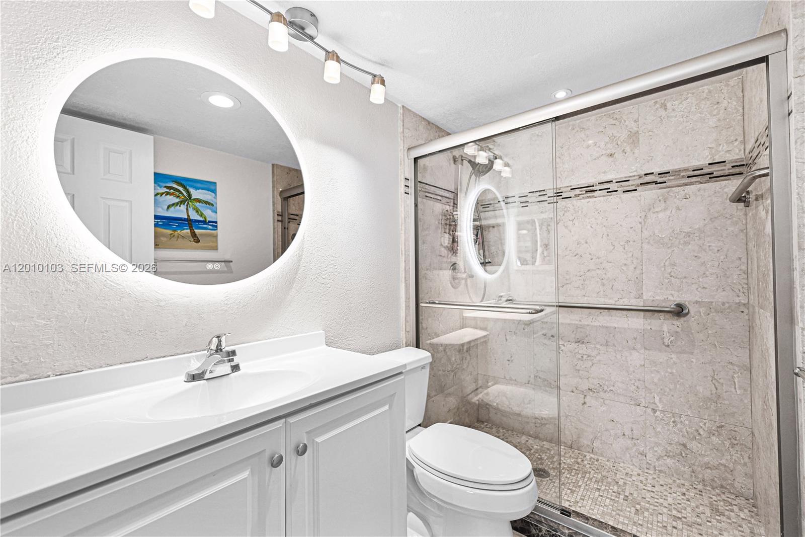 A covered patio features a wicker sofa, a metal chair, and a sliding glass door — 400 SE 10th St # 105, Deerfield Beach FL 33441, DEERFIELD BEACH, FL