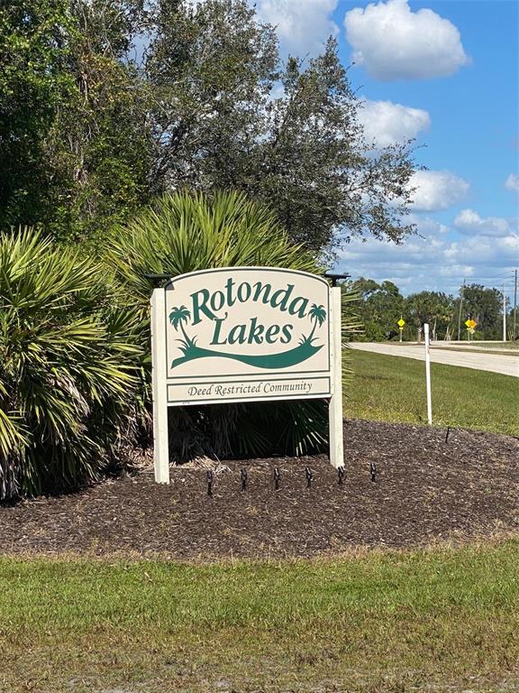 A sign for the Rotonda Lakes deed restricted community stands in a landscaped garden bed — 119 WAHOO DRIVE, ROTONDA WEST, FL