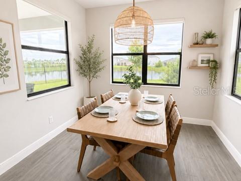 A dining room features a wooden table, woven pendant light, and large windows overlooking water — 2915 BLAZING STAR DRIVE, MELBOURNE, FL