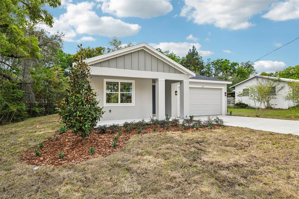 A modern, light gray single-story house with a garage and a landscaped front yard — 536 E BERESFORD AVENUE, DELAND, FL