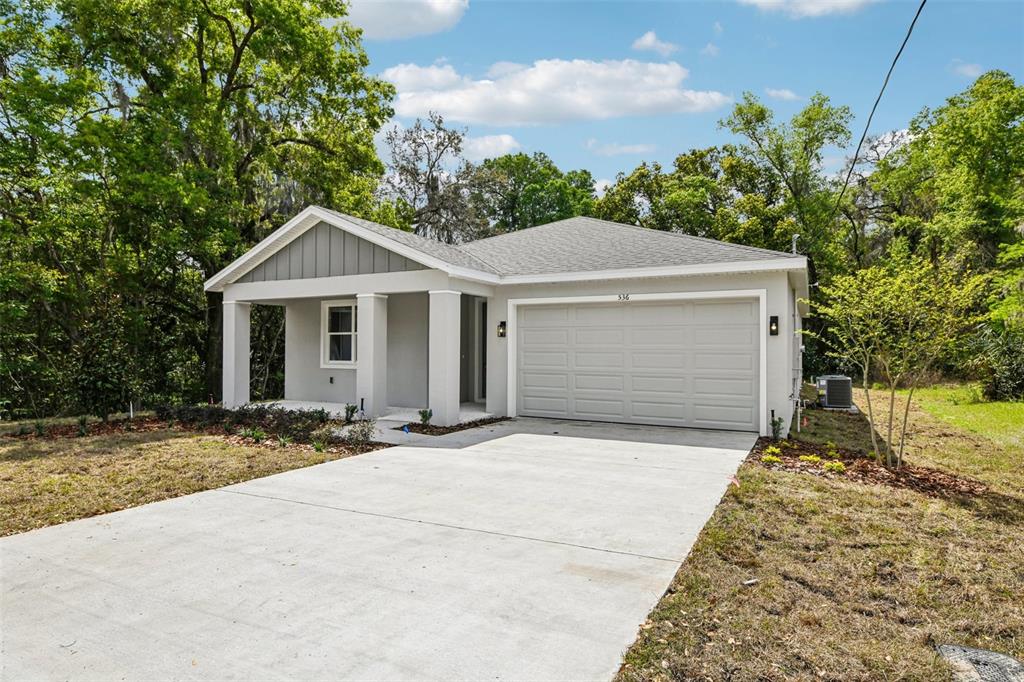 A single-story house with a gray exterior, a front porch, and a concrete driveway — 536 E BERESFORD AVENUE, DELAND, FL