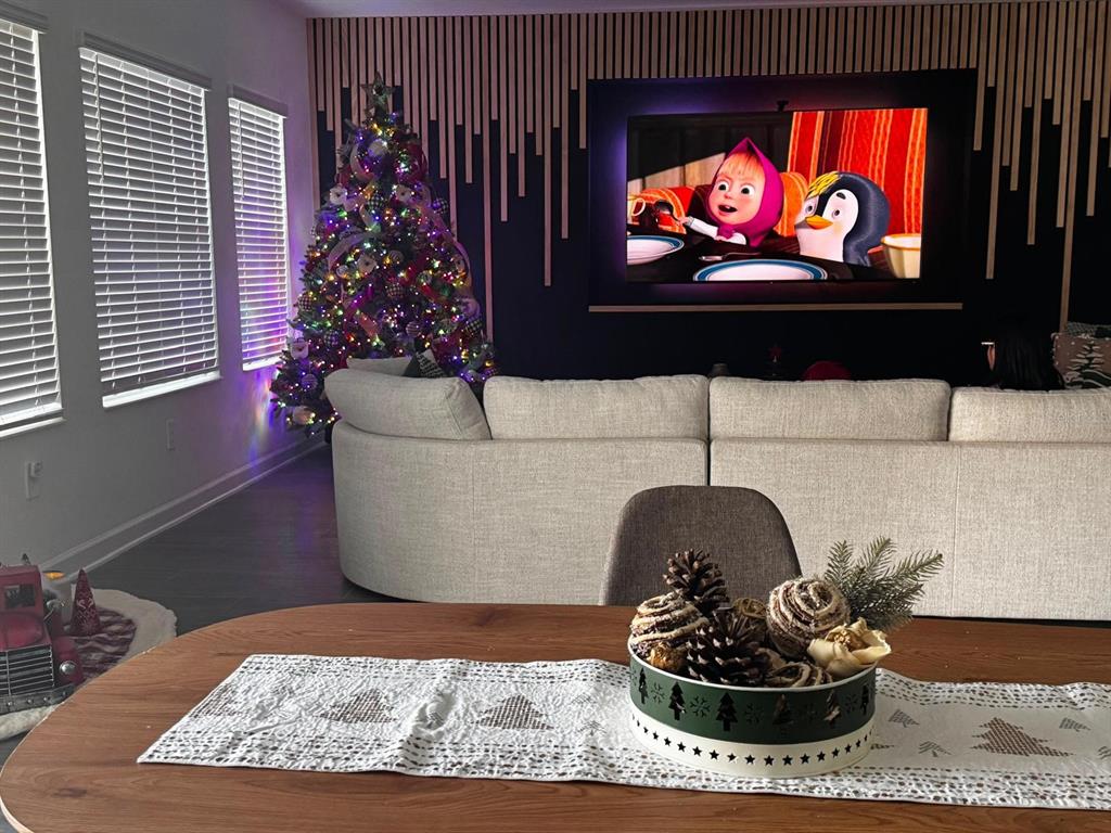 A living room features a large television, a Christmas tree, and a dining table centerpiece — 5779 STEPHENS ROAD, ST CLOUD, FL