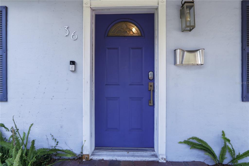 A single-story house with a blue front door, dark shutters, and a paved driveway — 36 E WINTER PARK STREETS, ORLANDO, FL