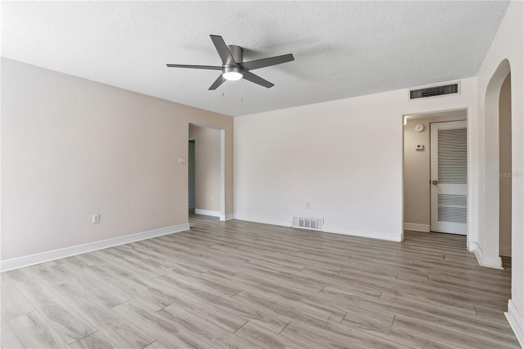 This virtually staged living room features light wood-look flooring, two sofas, and a patterned rug — 36 E WINTER PARK STREETS, ORLANDO, FL