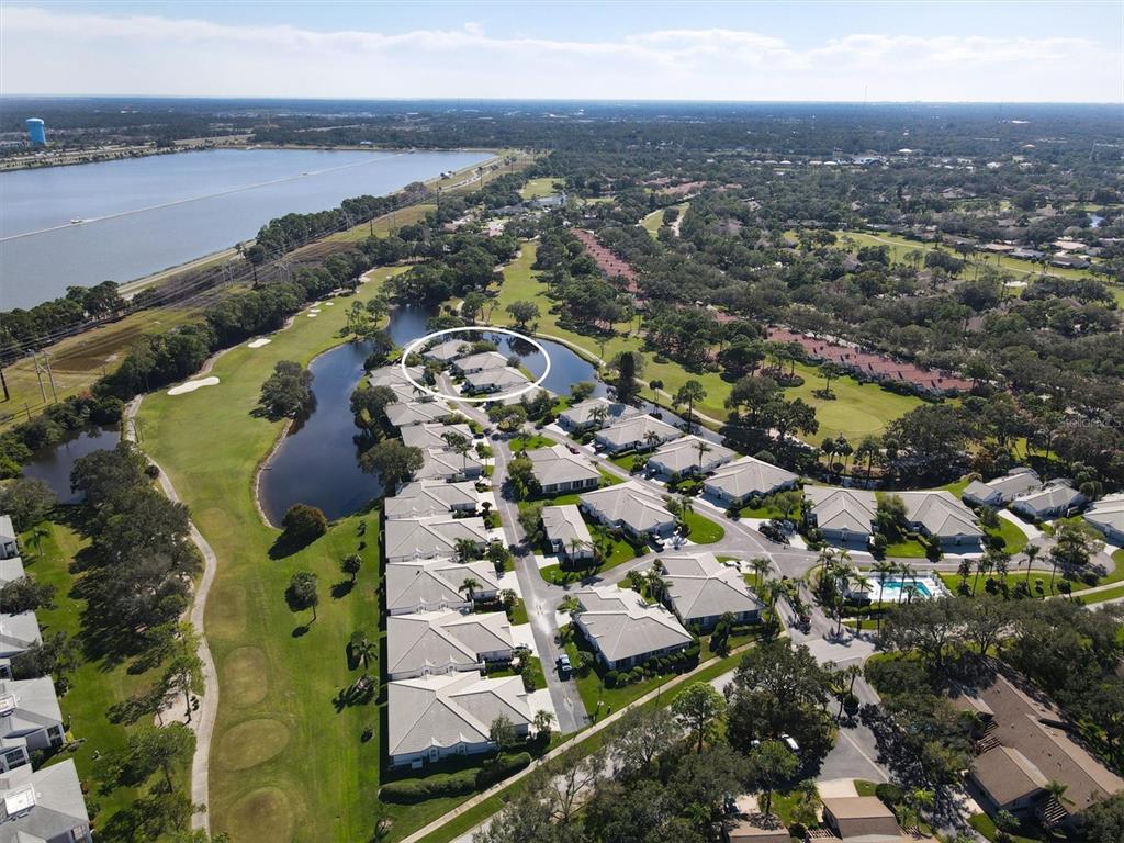 An aerial view shows a residential community with a circled cluster of homes near water — 5662 LONG COMMON CIRCLE UNIT 8, SARASOTA, FL