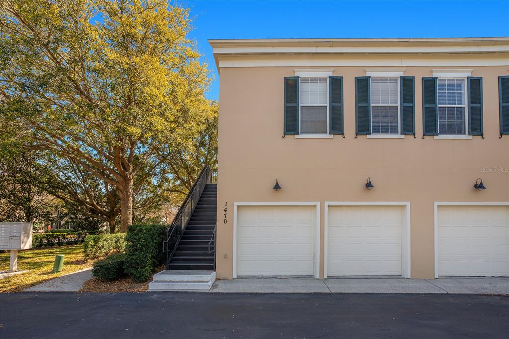An exterior view shows a tan building with three garage doors and an outdoor staircase — 1470 LAKE BALDWIN LANE UNIT C, ORLANDO, FL