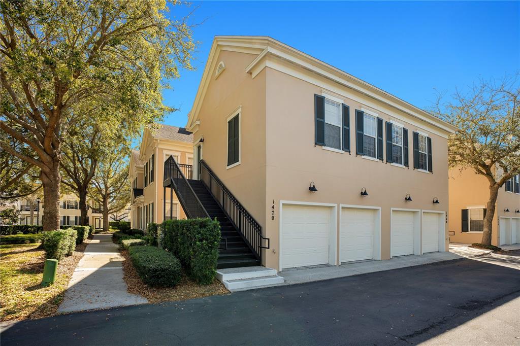 A two-story building with a tan exterior, four garage doors, and an outdoor staircase — 1470 LAKE BALDWIN LANE UNIT C, ORLANDO, FL