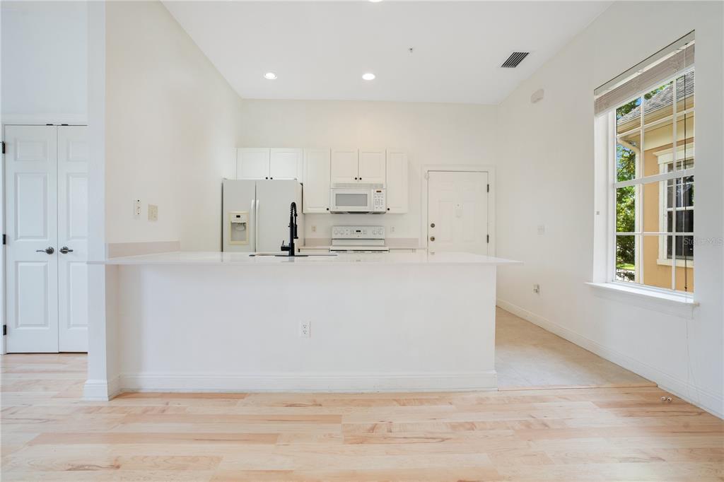A kitchen with white cabinets, stainless steel appliances, and a breakfast bar island — 1470 LAKE BALDWIN LANE UNIT C, ORLANDO, FL
