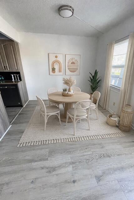 A dining area features a round wooden table, four chairs, and wall art on light flooring — 2075 Cornwall D # 2075, Boca Raton FL 33434, BOCA RATON, FL